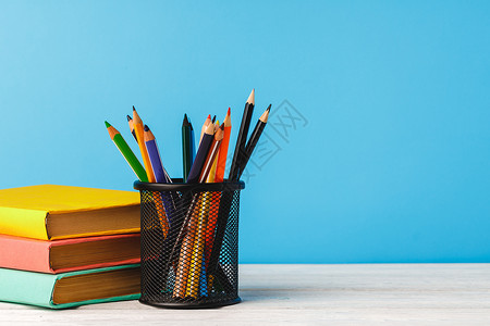 彩色铅笔杯和书本学校知识大学铅笔金属补给品持有者桌子图书笔筒背景图片