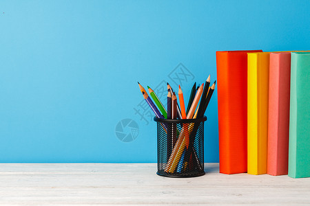 彩色铅笔杯和书本铅笔补给品持有者笔筒金属大学学校知识桌子图书背景图片