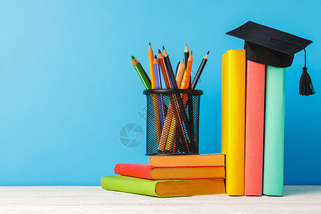 彩色铅笔杯和书本图书持有者学校桌子铅笔知识金属笔筒大学补给品背景图片