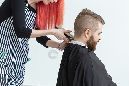 美发师 发型师和理发店的概念  女发型师剪胡须男客户男人女士成人沙龙发型修饰工作理发剪刀店铺高清图片素材