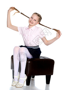 小女孩拉着自己的猪尾巴孩子童年头发学校情绪辫子微笑幼儿园金发金发女郎背景图片
