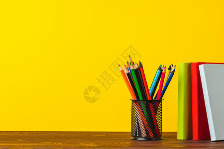 彩色铅笔杯和书本桌子大学图书笔筒持有者金属补给品知识铅笔学校背景图片