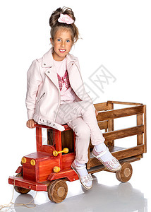 小女孩在玩木制汽车女孩火车学校婴儿乐趣童年车辆房间铁路地面背景图片