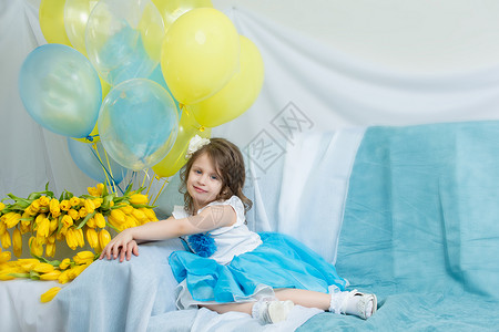 沙发上的小姑娘拿着一束鲜花裙子童年粉色展示黄色工作室母亲微笑礼物儿童天高清图片素材