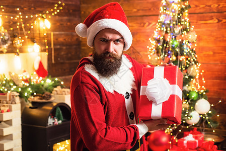 圣诞老人的胡子送礼物 礼物的情感 拿着礼物的圣诞老人 拿着礼物的红色圣诞老人帽子的赶时髦的人 胡子圣诞老人背景