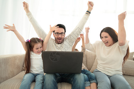 在笔记本电脑上观看他们最喜爱的电视节目男性展示屏幕游戏女儿童年父亲互联网男生房间背景图片