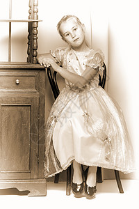 在美丽的旧床边桌子旁边的小女孩冠冕裙子头发微笑眼睛房间配件教育学校童年快乐的高清图片素材