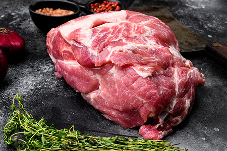 含有原料和草药 黑色黑黑石头桌底的生猪肉排牛排牛肉块背景图片