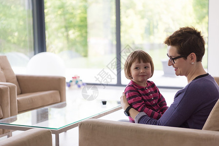 妈妈和可爱的小女孩 享受自己的空闲时间长椅幸福感情沙发童年亲热母亲乐趣父母拥抱女性高清图片素材