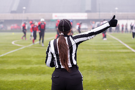 美国女性足球裁判员的后方视图橄榄球男人游戏行动警卫经编比赛女士竞赛球员背景图片