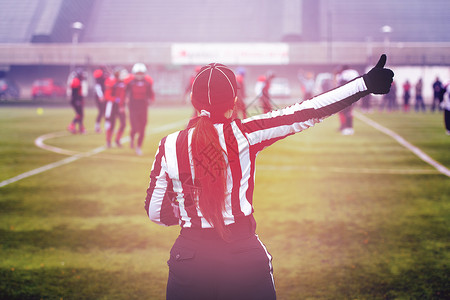 美国女性足球裁判员的后方视图运动员警卫大学游戏橄榄球竞赛锦标赛比赛场地裁判团队合作高清图片素材