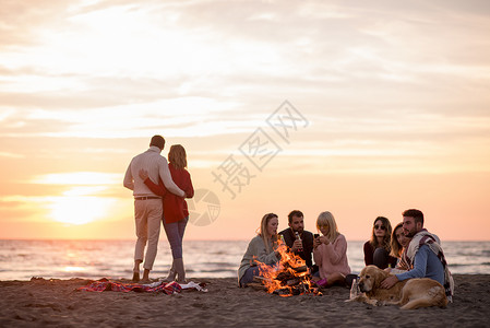 情侣潮搭在海滩日落时和朋友共度欢乐的情侣女性夫妻幸福旅行火焰朋友们友谊衣服假期潮人背景