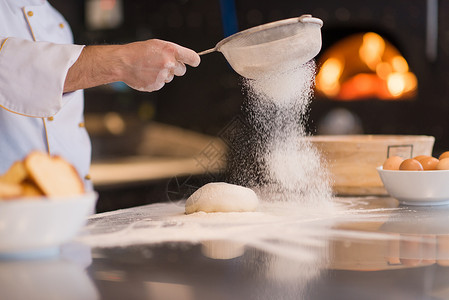 厨师面粉洒满新鲜比萨饼面团蛋糕烹饪面包烘烤厨房桌子滚动糕点手工面包师面包店高清图片素材