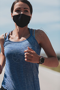 戴口罩跑步在冠状病毒爆发期间 穿着短衣 戴着红色防护面罩在城市户外跑步的坚定健身女性 Covid 19 和体育慢跑活动 运动和健身运动装训背景