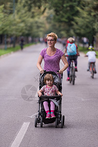 母亲推着婴儿车妈妈推着婴儿车慢跑慢跑者家庭活动跑步快乐公园运动娱乐母性运动员背景