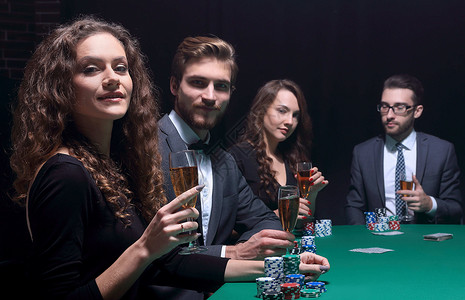 坐在赌场桌边的漂亮美人派对游戏投注朋友们乐趣裙子胜利筹码优胜者成人背景图片