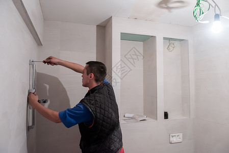 在卫生间工作的专业水管工金属浴室安装淋浴脸盆维修管道工具修理工男性房子高清图片素材