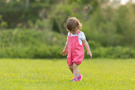 愉快地奔跑小女孩在后院花时间跑步开支院子孩子家庭女孩公园乐趣童年季节背景