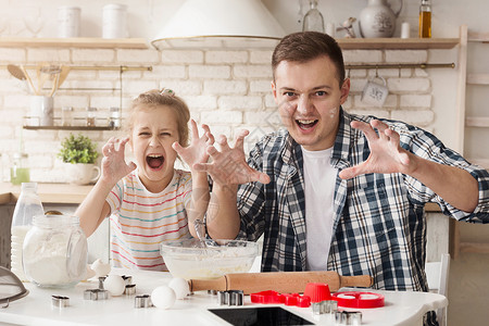 父亲和女儿在烘烤时玩得开心高清图片