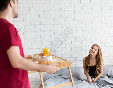 丈夫带早餐给在卧室的喜悦妻子男性高清图片素材