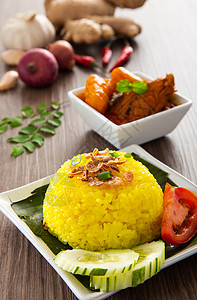 被惹我Nasi Kunyit也被称为通常用干咖喱鸡吃糯米椰子盘子美食午餐黄色财富食物香料仪式背景