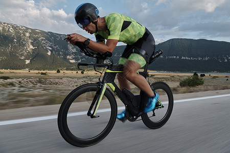 山自行车骑自行车的三重运动员钢铁侠头盔活力娱乐行动训练男性健康运动轮子背景