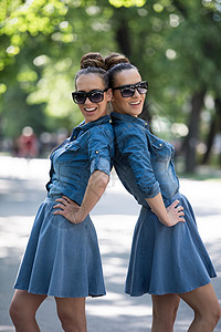 有太阳眼镜的姐妹姊妹公园双胞胎微笑幸福衣柜朋友们闺蜜成人女孩们头发时尚高清图片素材