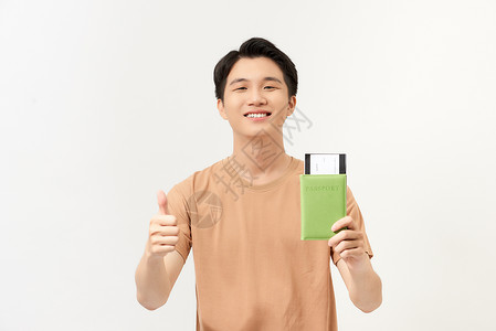 一个快乐的年轻人的肖像 持有护照 显示拇指 在白色背景上孤立无助年轻的高清图片素材