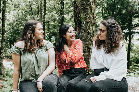 三名年轻女子在阳光明媚的白天在森林里聊天 充满爱和友谊 微笑和关心 (三)背景图片