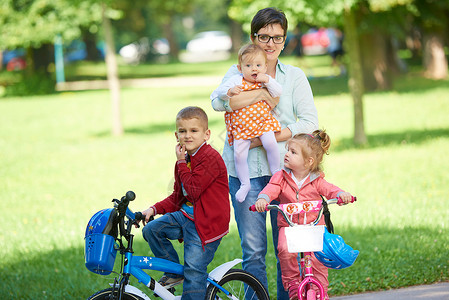 公园中快乐的年轻家庭婴儿幸福童年妈妈儿子男生自行车闲暇乐趣女性春天高清图片素材