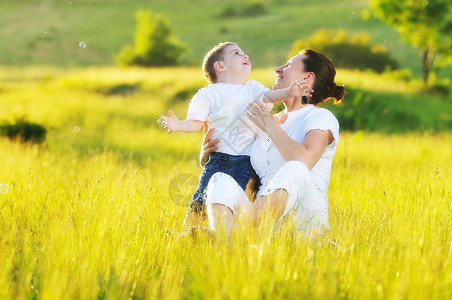 户外妇女儿童微笑儿子天空健康女士男生成人母亲女性草地夏天高清图片素材