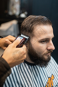 理发店主用剪发机给男人理发治疗商业男性胡子修剪客户程式化工具剪子美容师发型高清图片素材