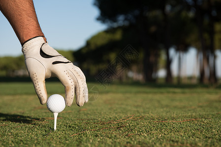 高尔夫手套高尔夫球员手上紧贴的高尔夫球手游戏俱乐部皮革蓝色天空玩家活动训练运动力量背景