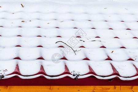 屋顶的瓷砖上有一层薄厚的雪背景图片
