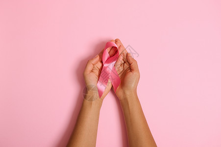 全国法律咨询日平躺的手拿着粉红色背景上的粉红色丝带 乳腺癌意识 十月粉红日 全国癌症幸存者说 妇女保健和医疗理念 复制空间背景
