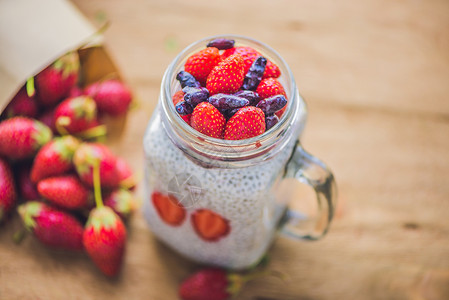 健康层层甜点 配有辣椒布丁 草莓和蜂蜜 在生锈背景的泥瓦罐中蓝莓高清图片素材