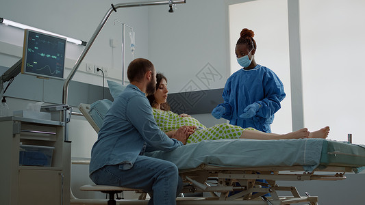 拥有医疗设备的孕妇在医院病房中就座人数腹部技术病人怀孕母性母亲婴儿保健劳动丈夫女士高清图片素材