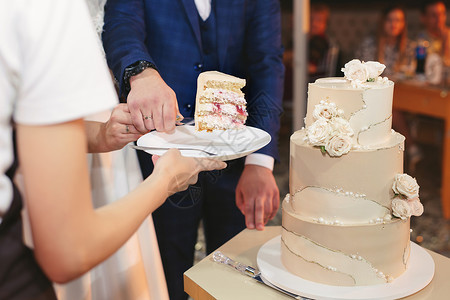 结婚宴席新娘和新郎在宴席上切了个漂亮的婚礼蛋糕桌子仪式夫妻套装食物奶油甜点丈夫男性传统背景