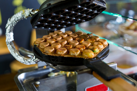 华夫饼烤机器在香港的店里制造了泡泡华夫饼背景