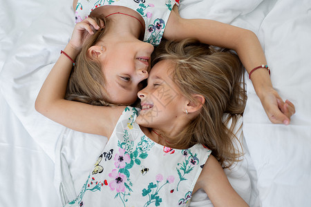 两个双胞胎姐妹躺在床上兄弟姐妹高清图片素材
