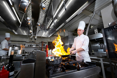 厨师在厨房炉子上用火烧锅煮饭酒店炊具燃烧油炸男性烤箱职业烹饪火焰餐厅背景图片