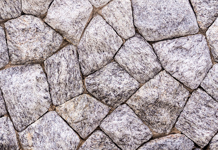 由大尺寸花岗岩制成的墙壁纹理鹅卵石建筑学岩石材料灰色石墙水泥白色背景图片