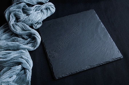 黑灰色线条黑色板子在黑石纹的顶端 上面有灰色纱布桌布背景