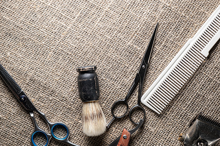 古典理发师用危险的剃须刀剪剪刀 旧的手动剪布梳子 在麻布背景上刮刷卫生高清图片素材