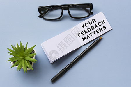 带阅读眼镜的注纸上的文字和蓝色背景的陶植植物证明书工作事项批评建设性报告商业反馈客户顾客背景图片