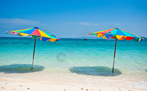 蓝色伞在泰国普吉海滩上 富彩多彩的伞下坐着沙滩椅旅游天空支撑阳伞赤道海岸线海浪晴天椅子背景