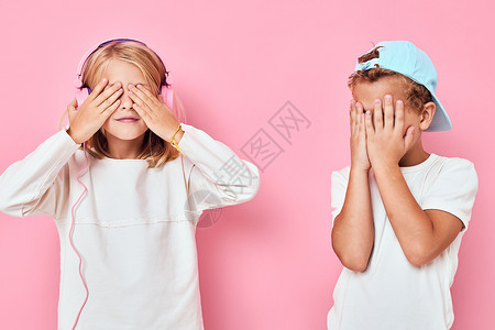 一个身着帽子的男孩和一个女孩肩并肩站在一起 装作时装孤立的背景背景图片