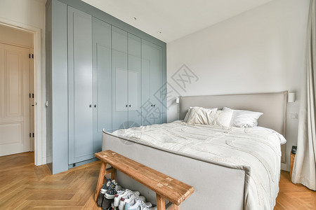 经典风格的卧室内室内白墙设施木地板枕头家具高脚椅床单衣柜蓝色软床背景图片