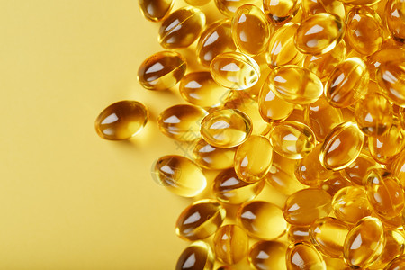 高分辨率素材在无空间的黄色背景上 用维他命D3金胶囊药片治疗药物营养胶囊脂肪酸工作室鱼油制药饮食背景