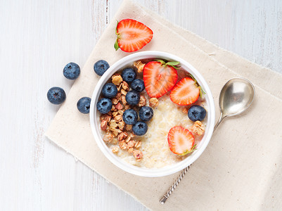 麦片粥碗含草莓 蓝莓 白木本底的麦片粥 健康早餐 顶端视图木头水果奶制品谷物饮食甜点牛奶粮食食物燕麦背景